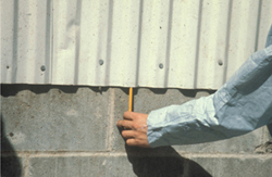 Figure 3. Mice can enter the wall space where the ends of metal siding panels are open by gnawing through the weather shield or vinyl gasket. Use concrete, angle iron, or heavy duty flashing to block access to rodents.