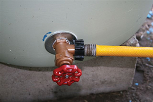 Figure 4. Rain barrel water outlet — a hose bibb with hose attached for dispersing water. 