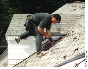 Figure 7. A professional placing a squirrel cage trap on a roof.