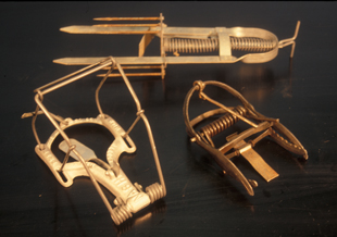 Figure 4. Mole traps clockwise starting from the top: Victor® (harpoon), Out O’ Sight® (scissor-jaw), and Nash® (choker- loop).